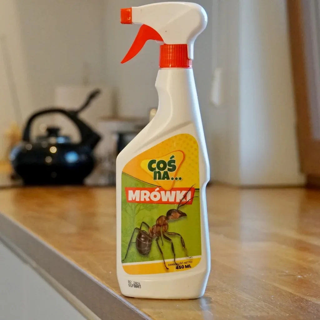 środek zwalczający mrówki w domu postawiony na drewnianym blacie w kuchni